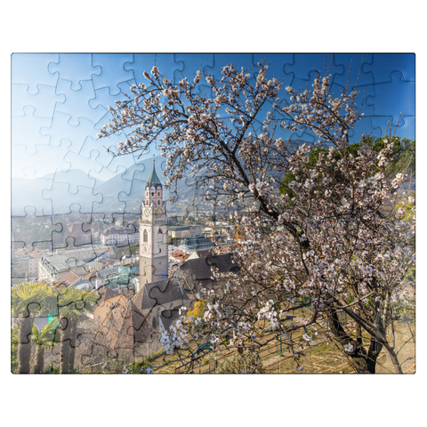 puzzleplate Blossoming almond tree with view from Tappeinerweg to the old town with the parish church of St. Nicholas 100 Jigsaw Puzzle